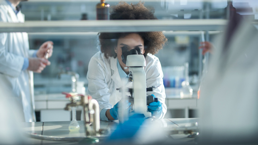 scientists looking through a microscope in a lab