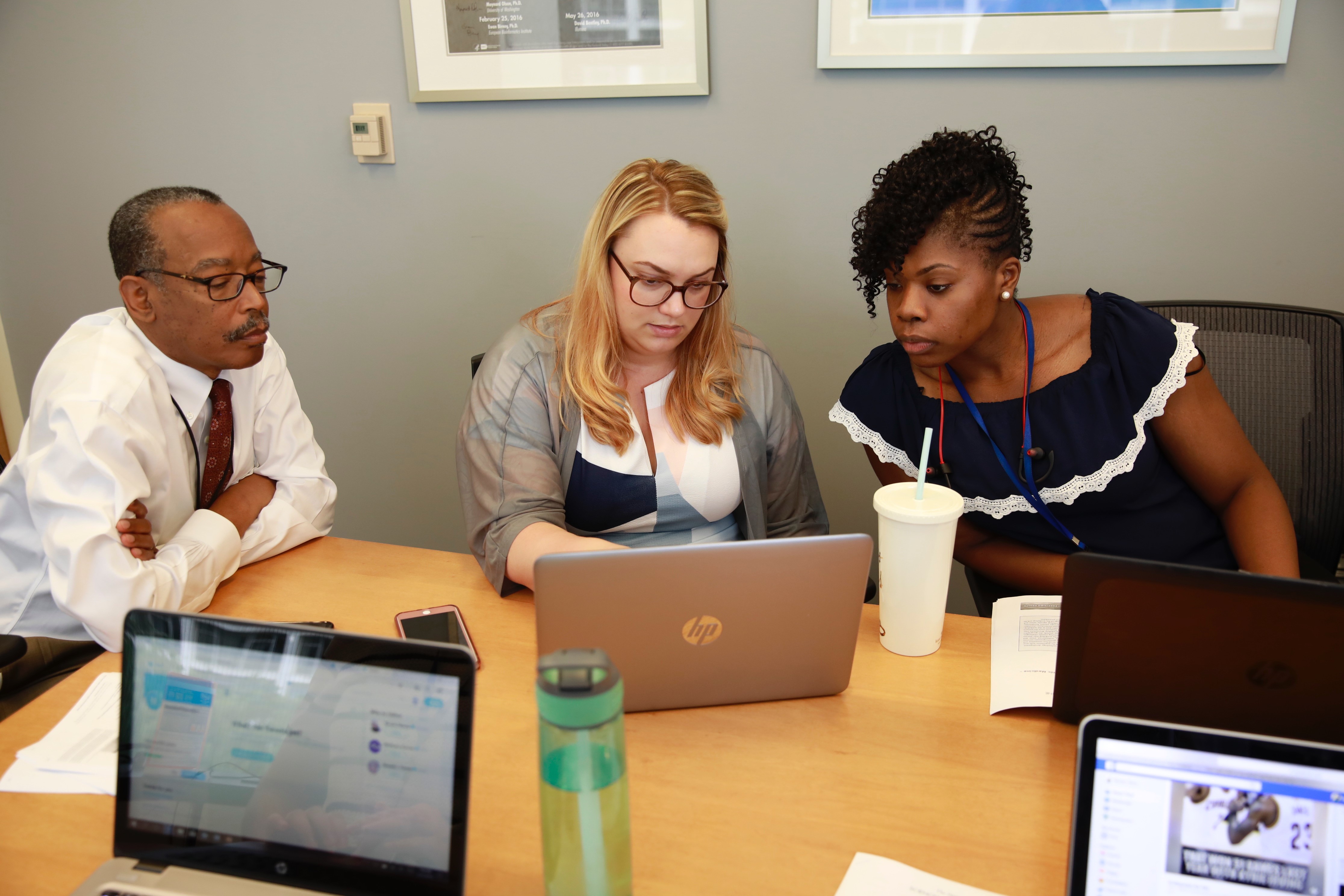 Staff members type on a computer