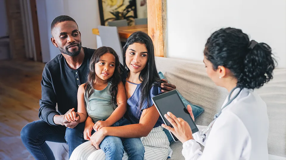 family with a young girl reviewing forms with a healthcare worker